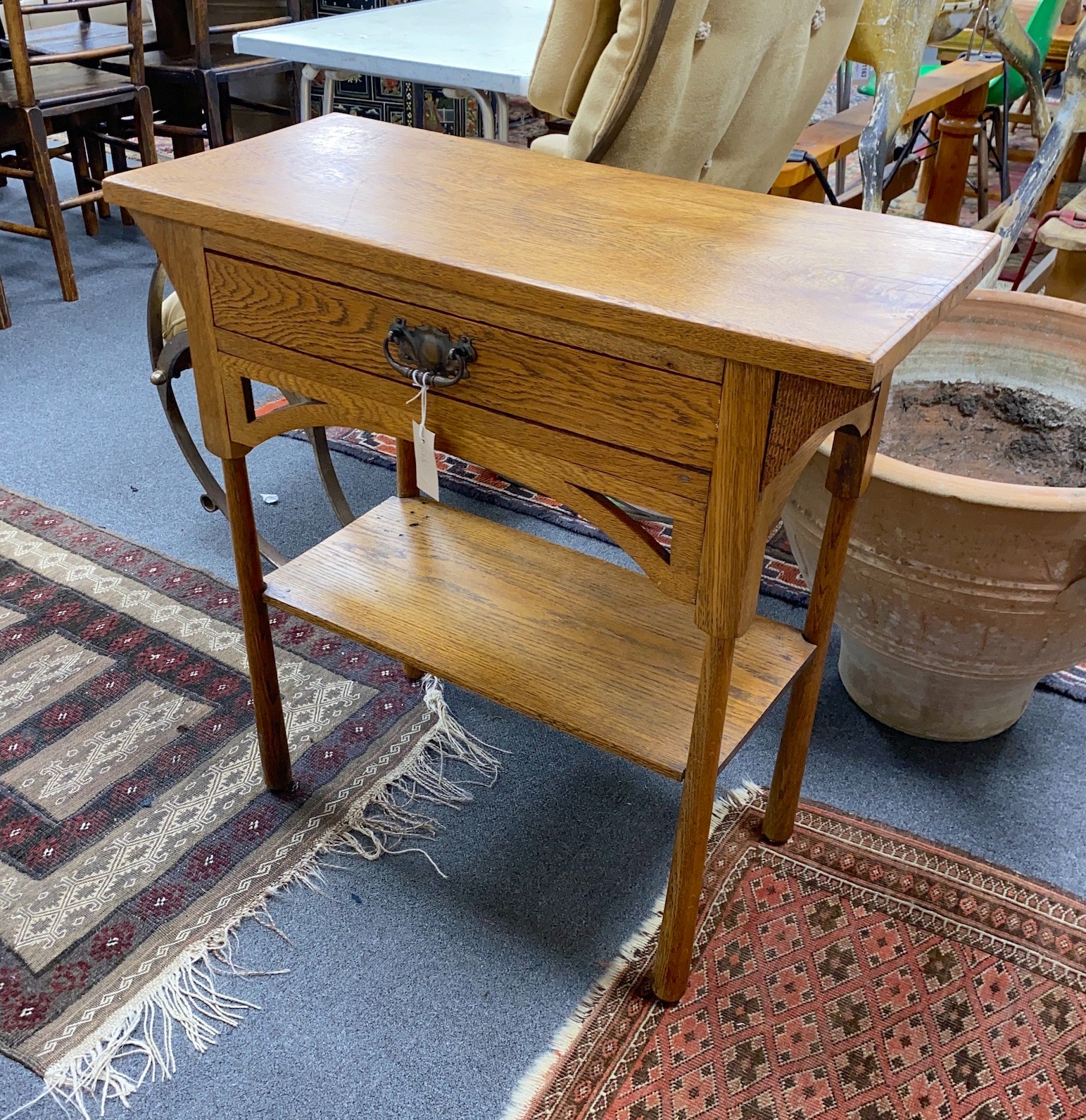 An Arts & Crafts oak two tier side table, width 76cm, depth 33cm, height 77cm